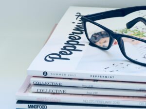 Eyeglasses on a stack of fashion and lifestyle magazines including Peppermint and Collective.